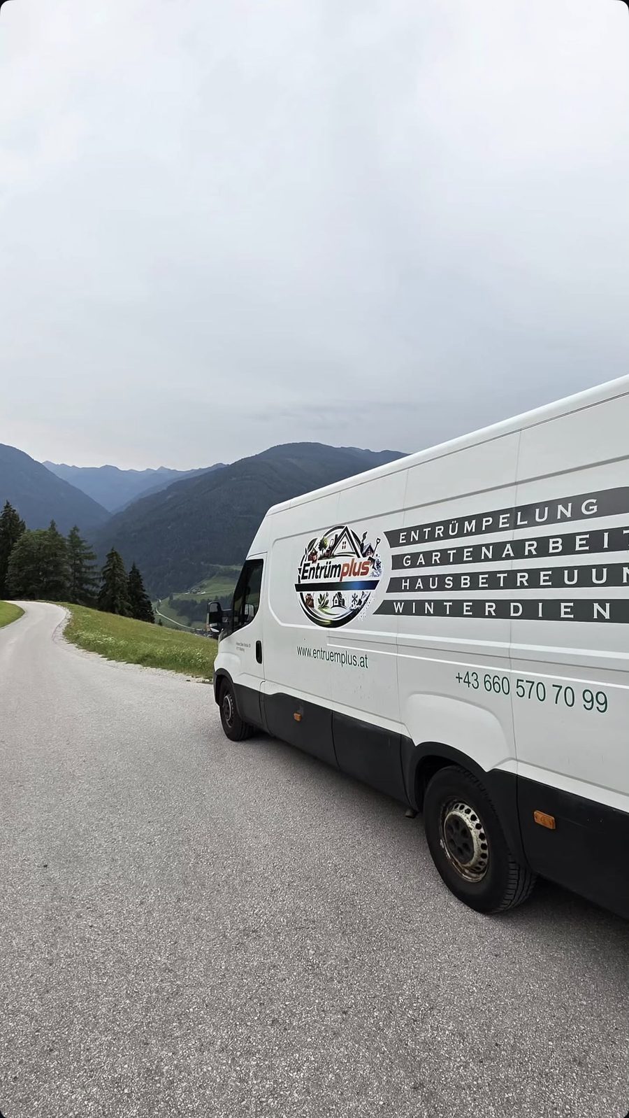 Weißer Entrümplus-Transporter auf einer Bergstraße
